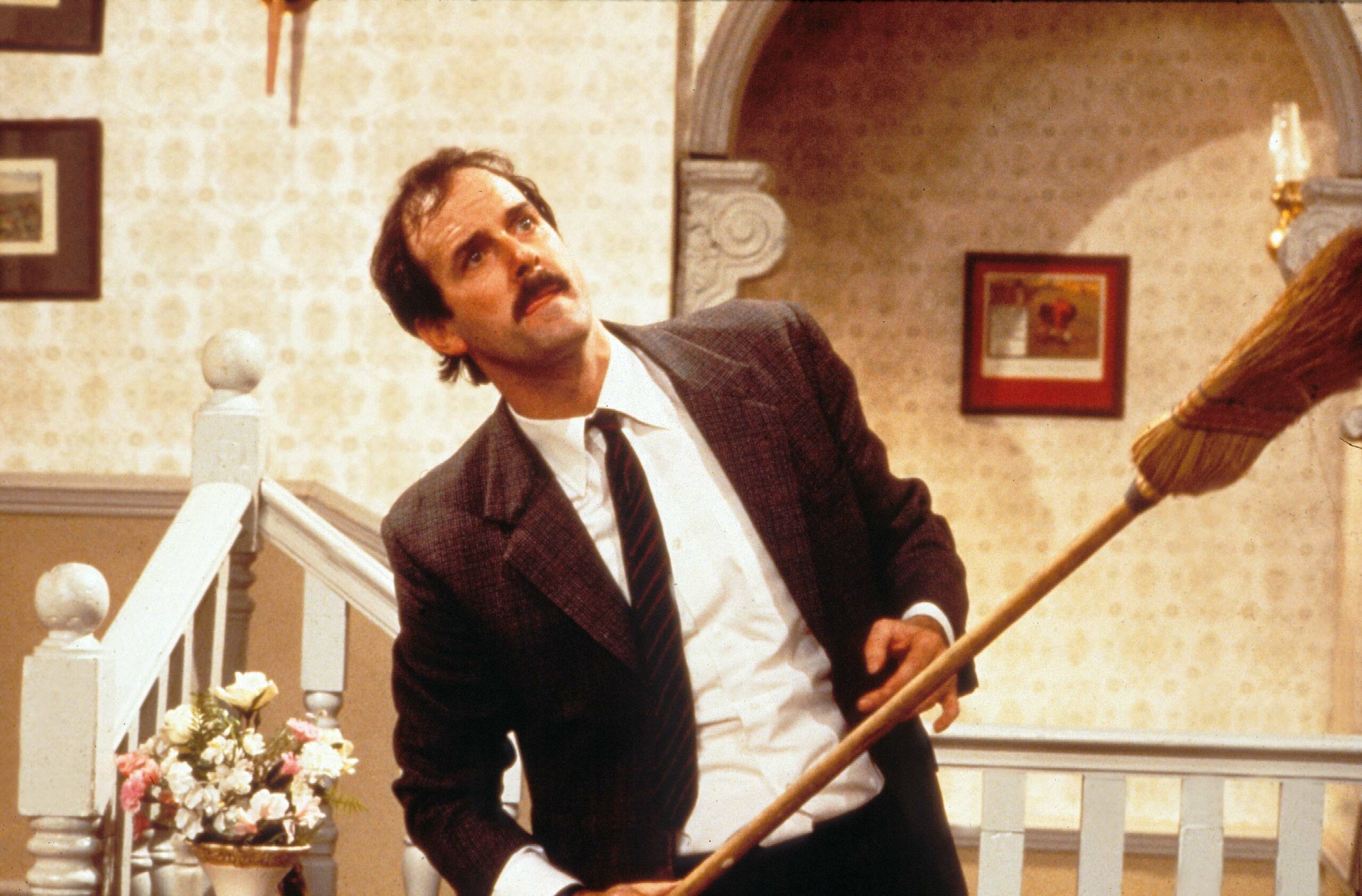 Fawlty frowns with a broom in Fawlty Towers