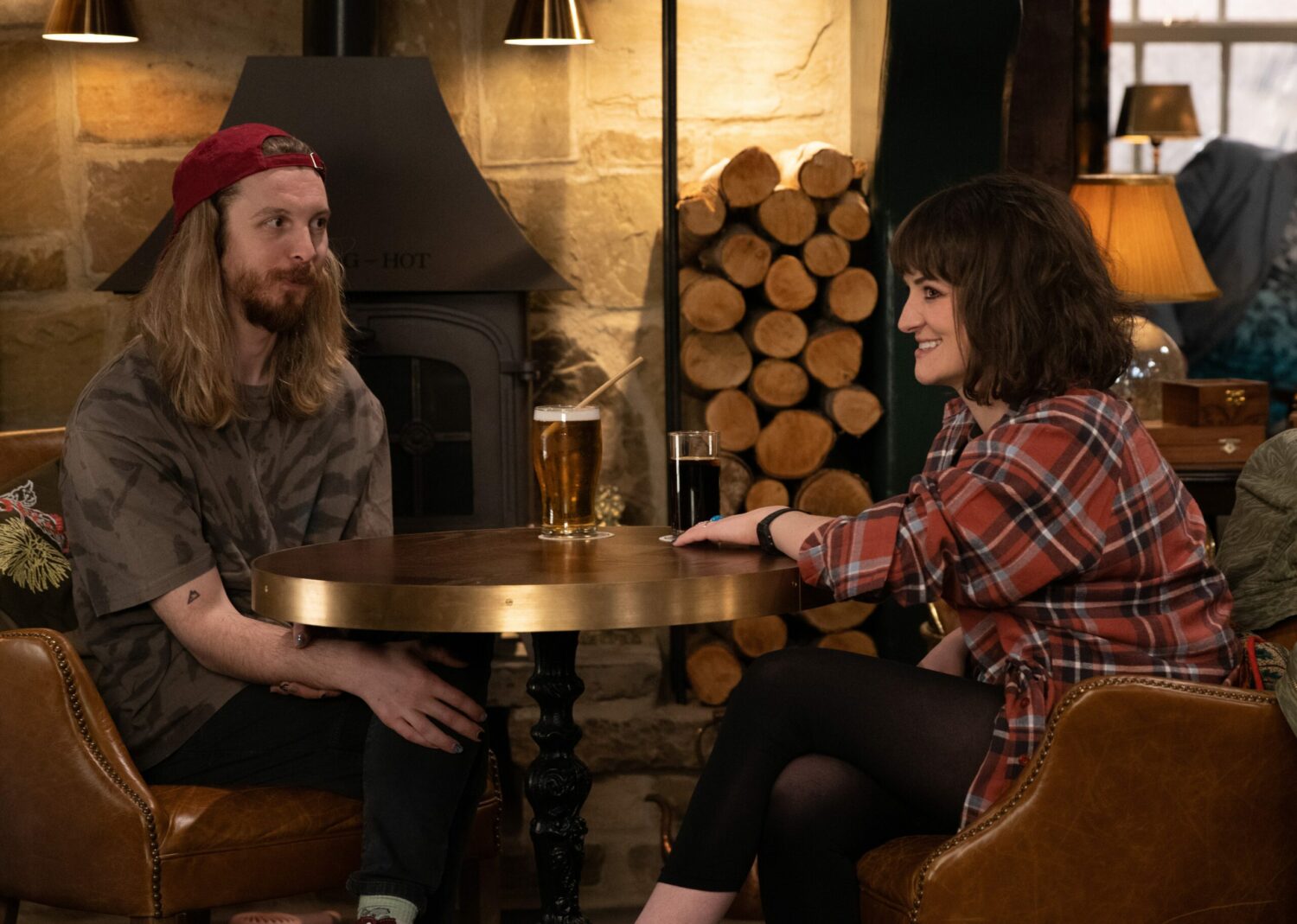 Ryan and Gail in Emmerdale smile at each other over a drink in the pub