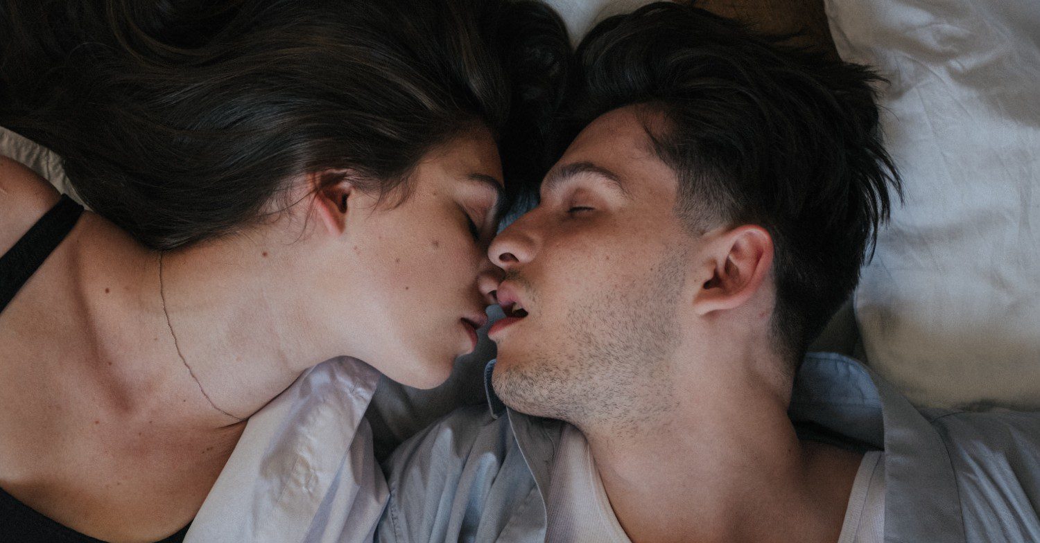 People kissing on a bed