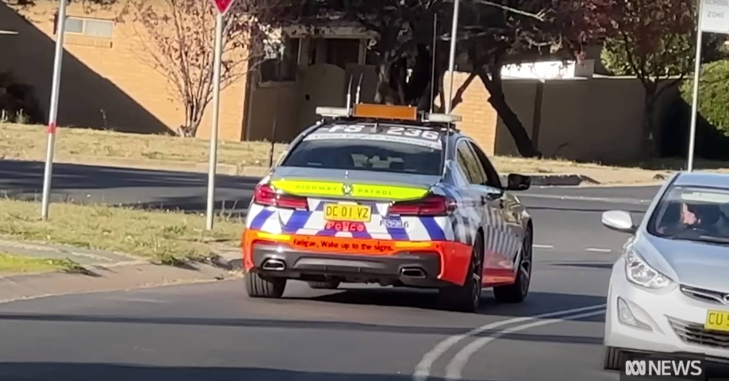Police car drives down street