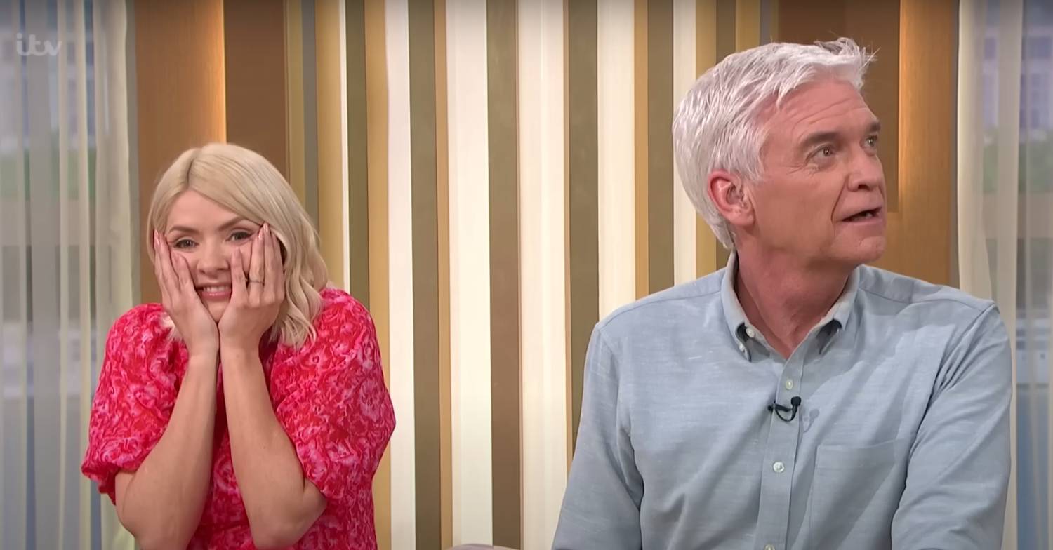 Holly holds her face in her hands, and Phil looks up