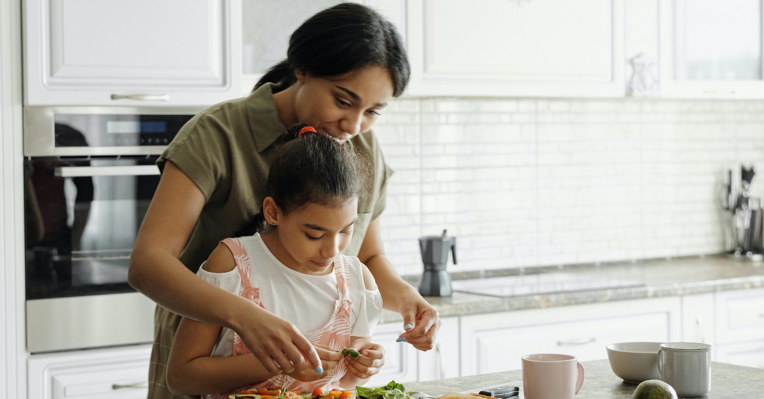Woman cooking at home with her daughter 