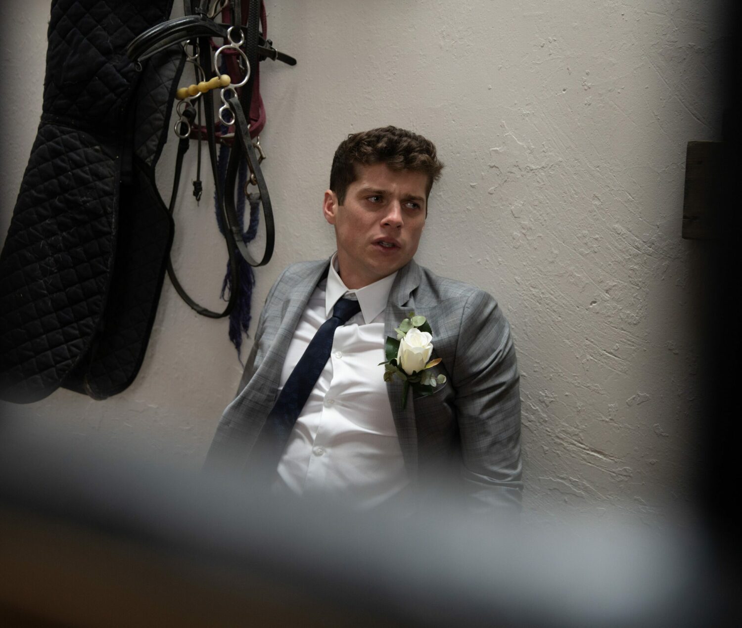 Nicky in Emmerdale looks upset as he lies in a heap slumped against a wall