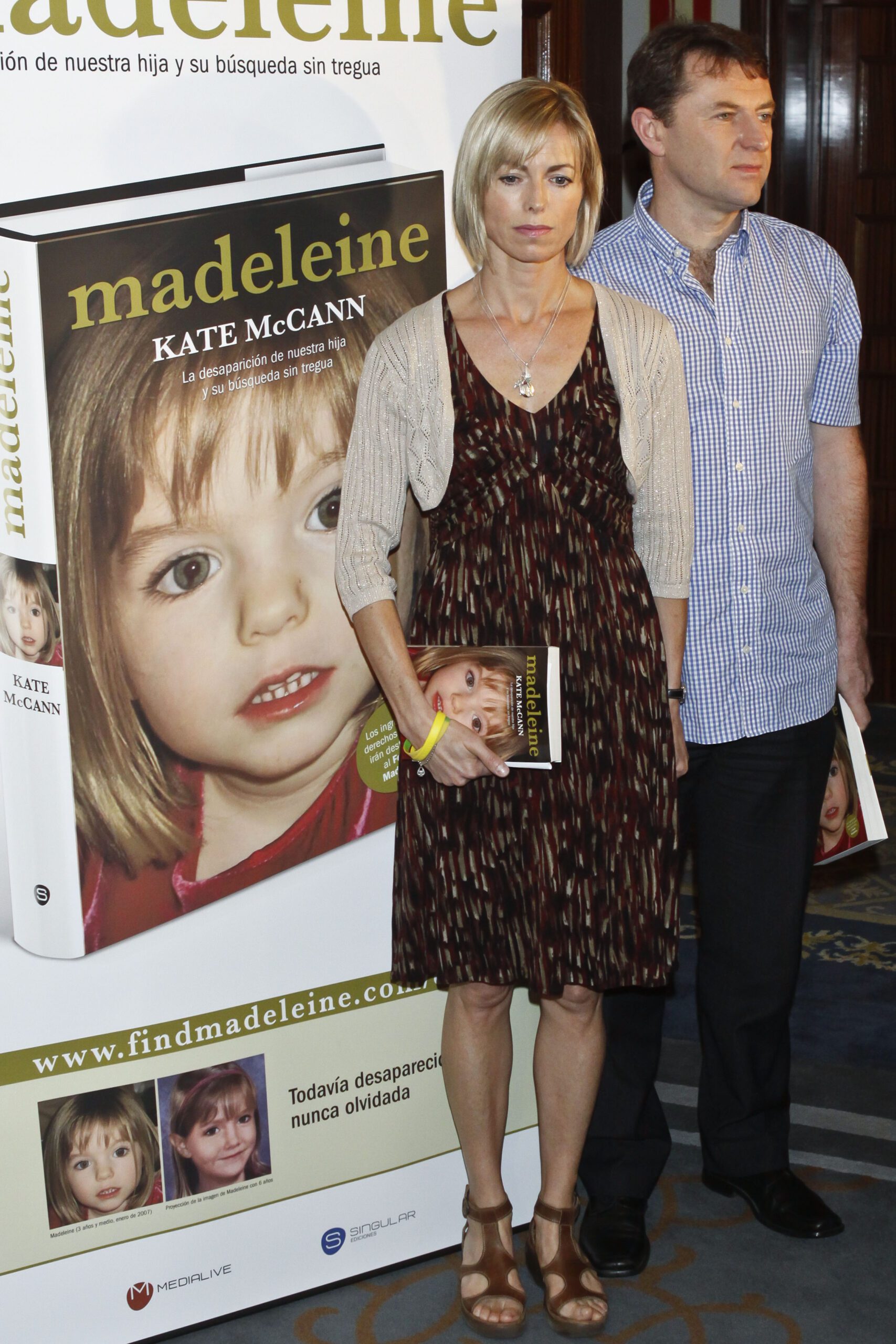 Kate and Gerry McCann beside a poster of Madeleine