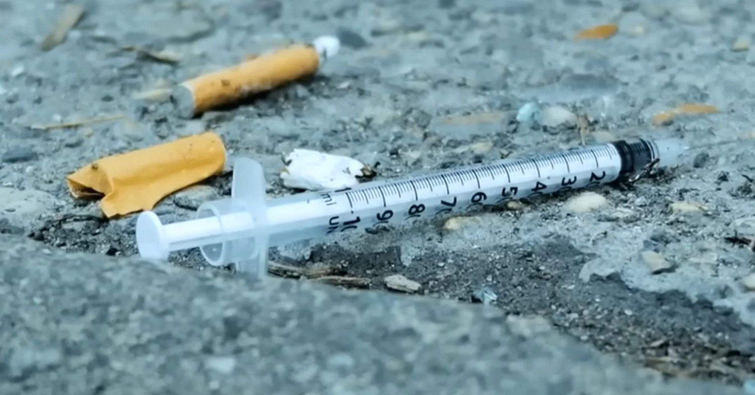 Cigarettes and a syringe on the floor
