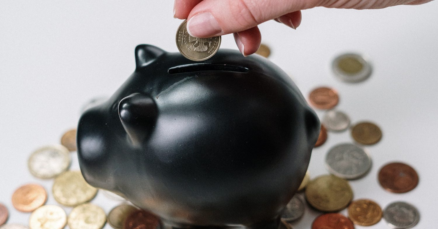 A pig bank with a coin going in