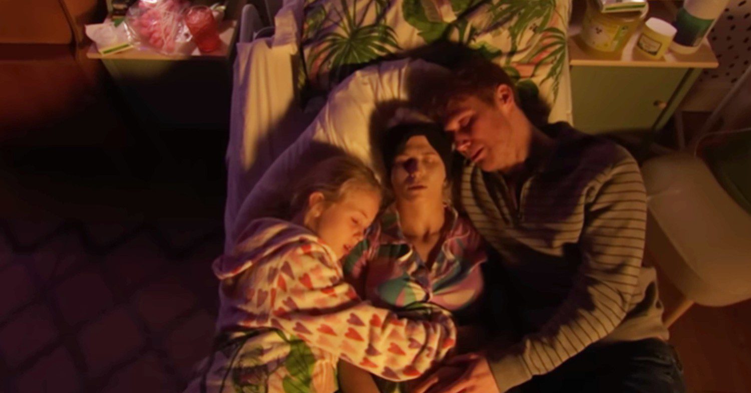 Jay and Lexi hold Lola as she dies in bed on EastEnders (Credit: BBC/YouTube)