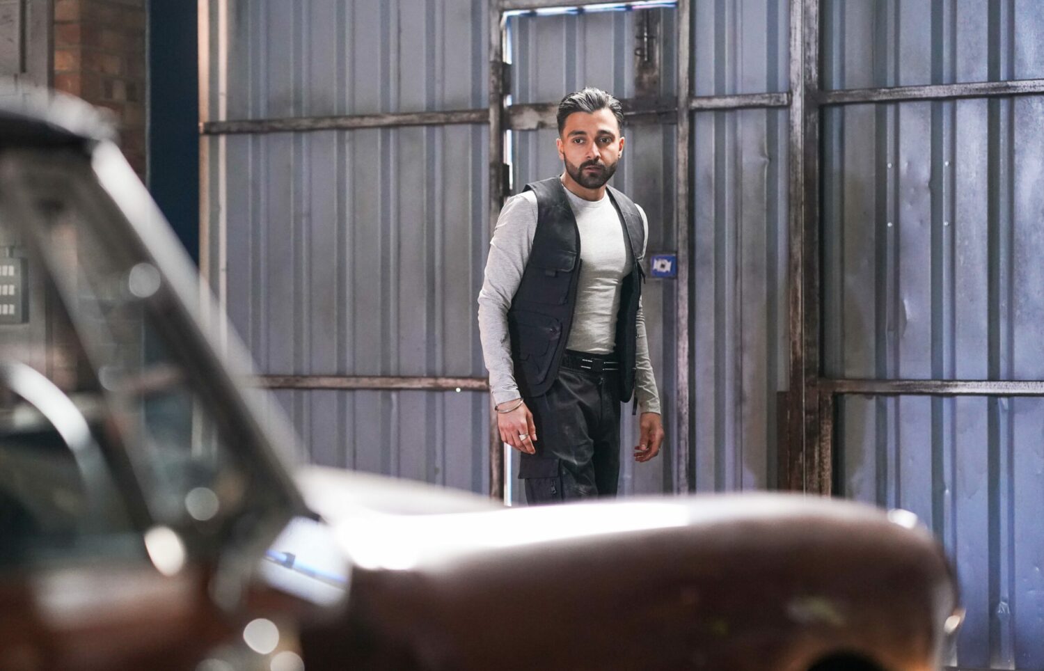 Vinny in EastEnders looks at the car anxiously 