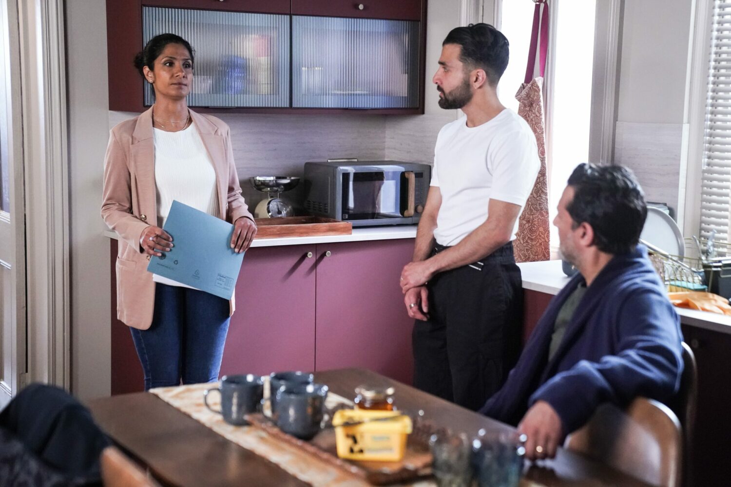 Suki Panesar clutches a folder as she talks to Vinny and Nish looking tense