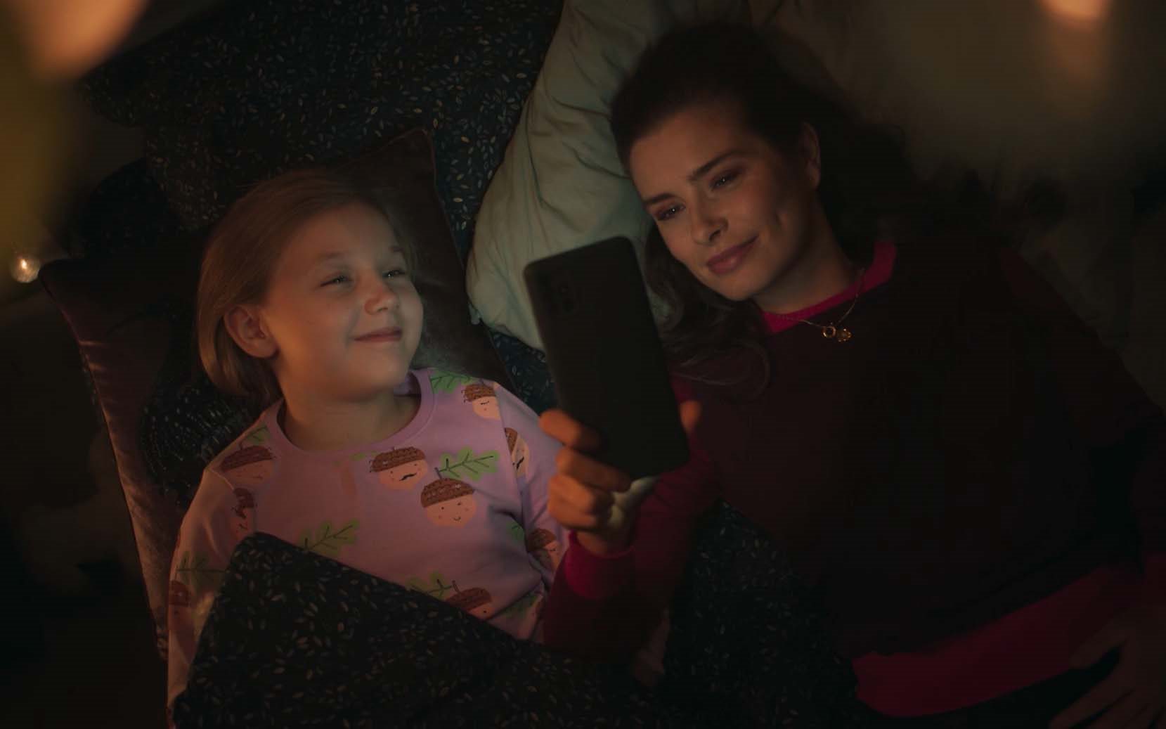 Eliza and Emily smile together in bed