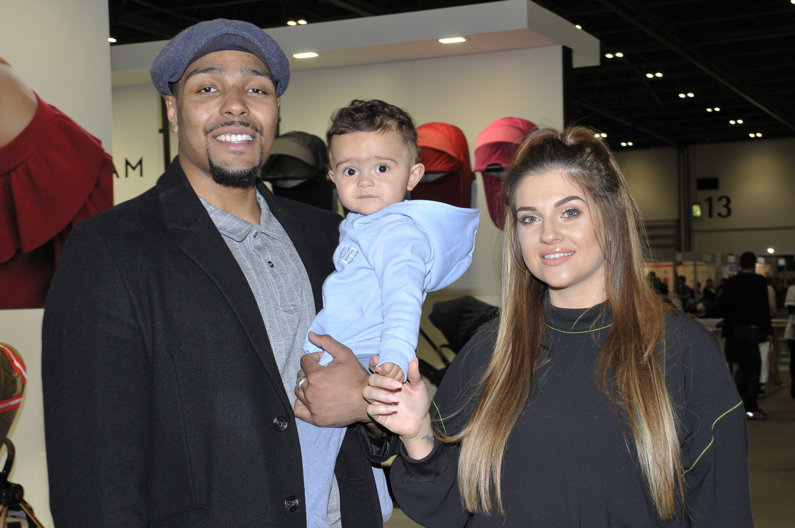 Jordan and Naomi Banjo holding son Cassius and smiling
