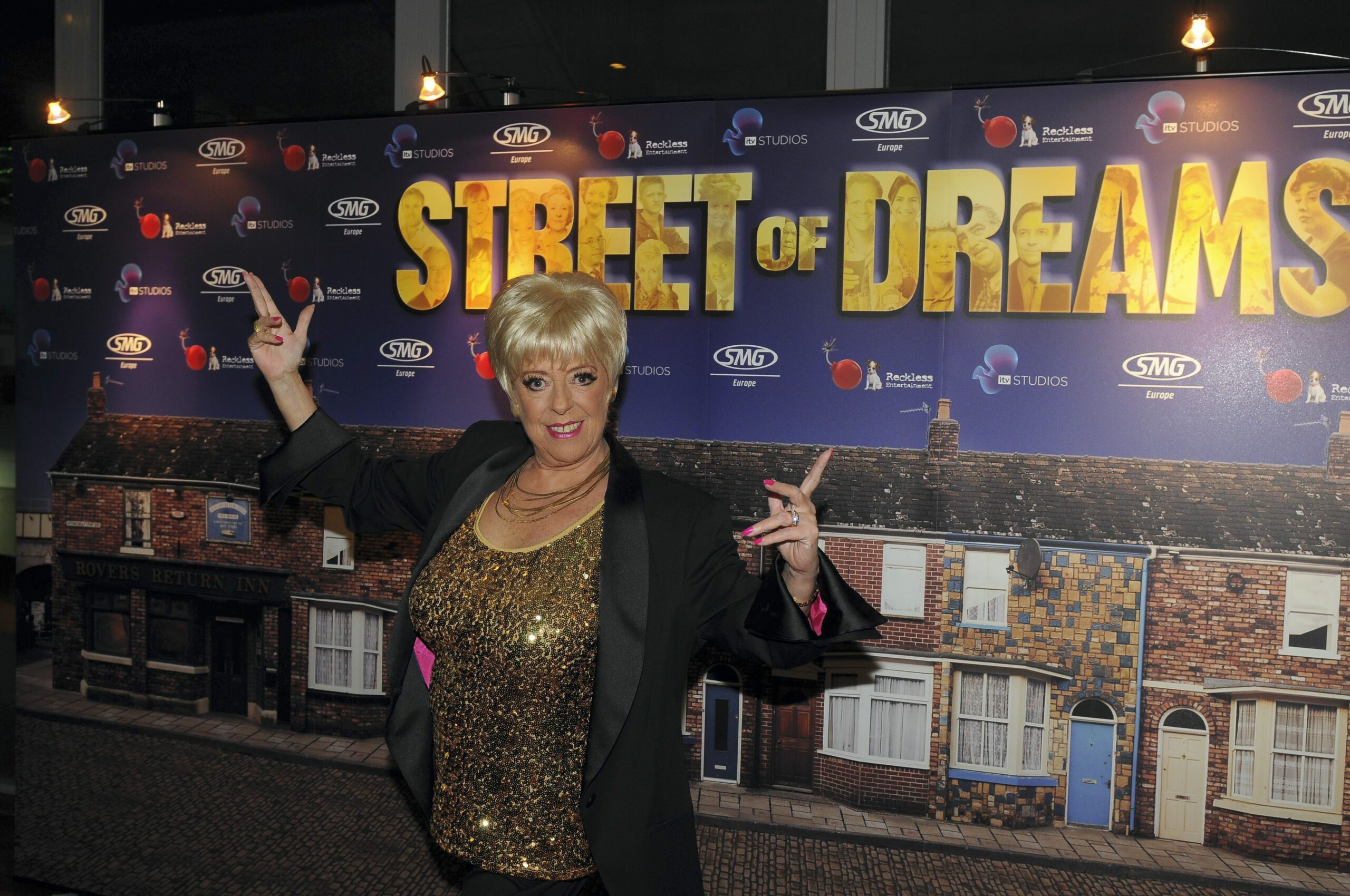 Julie Goodyear stands outside Street of Dreams promo board