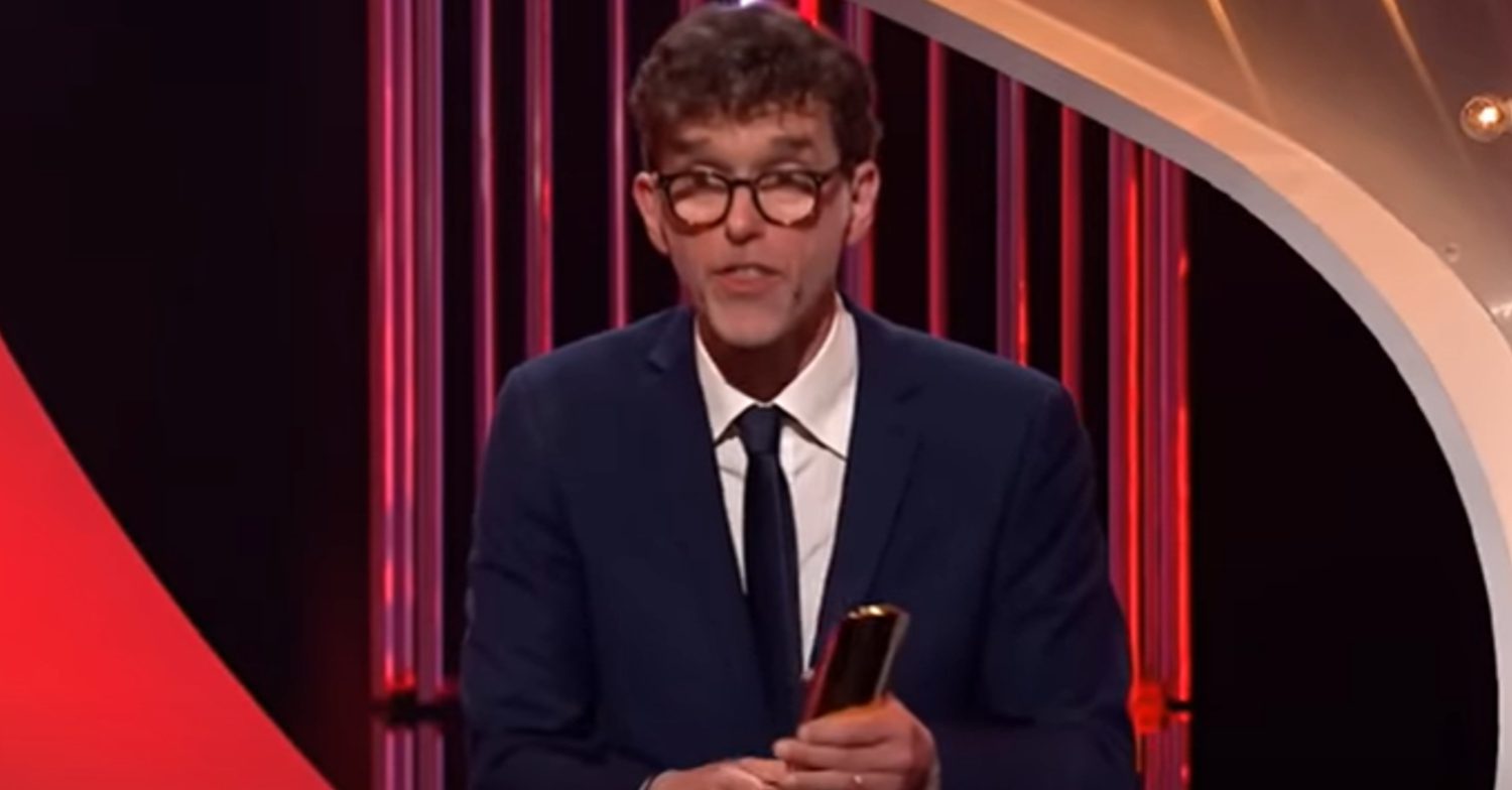 Emmerdale's Mark Charnock is holding an award at the soap awards
