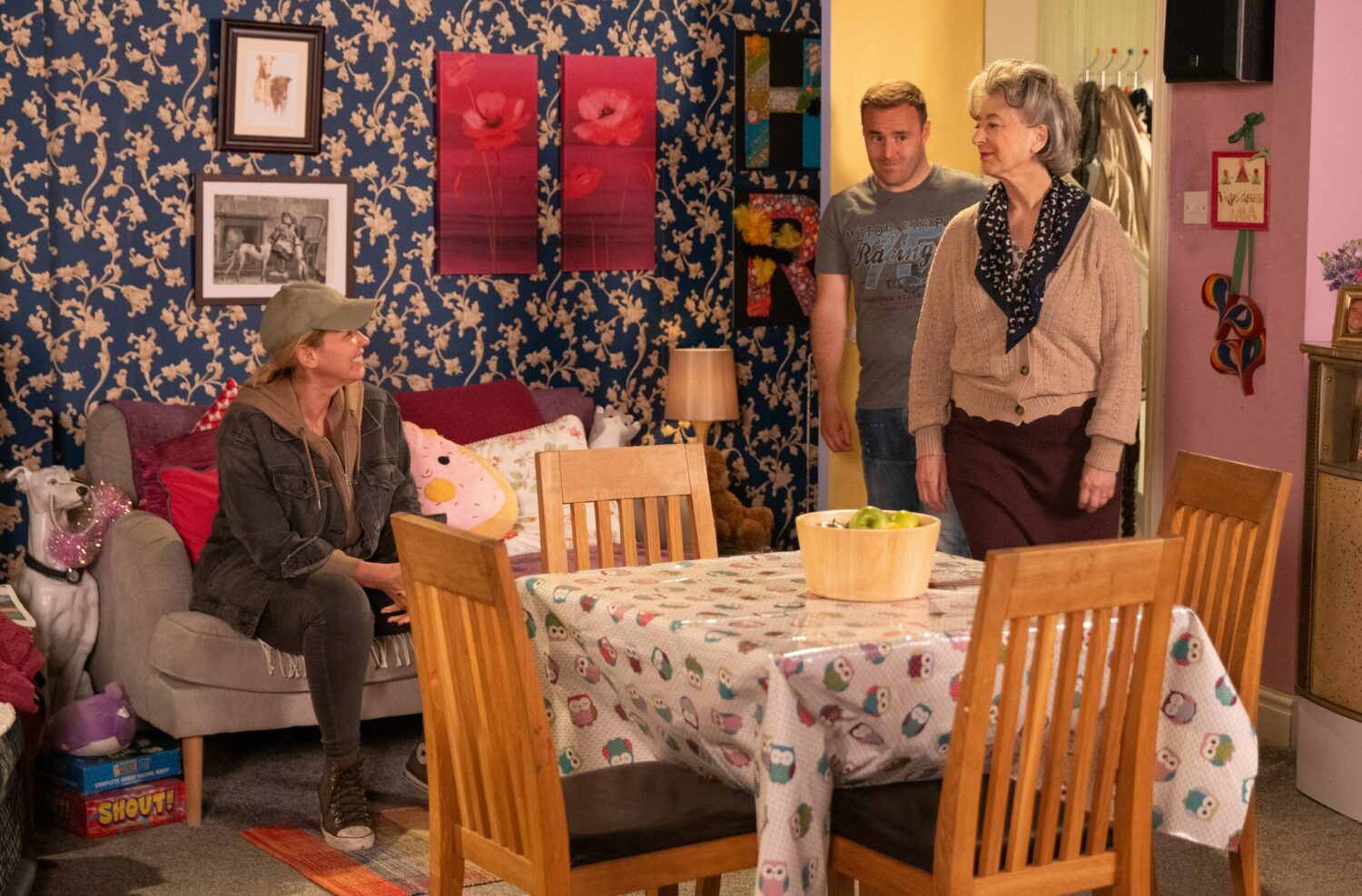 Evelyn and Tyrone look on as Cassie sits on the sofa in their home on Corrie