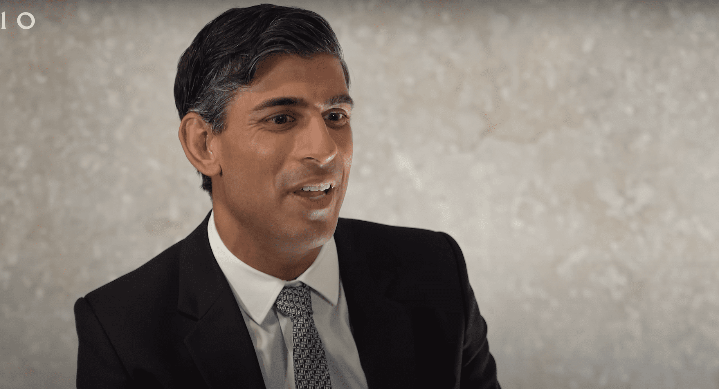Rishi Sunak being interviewed against a grey wall