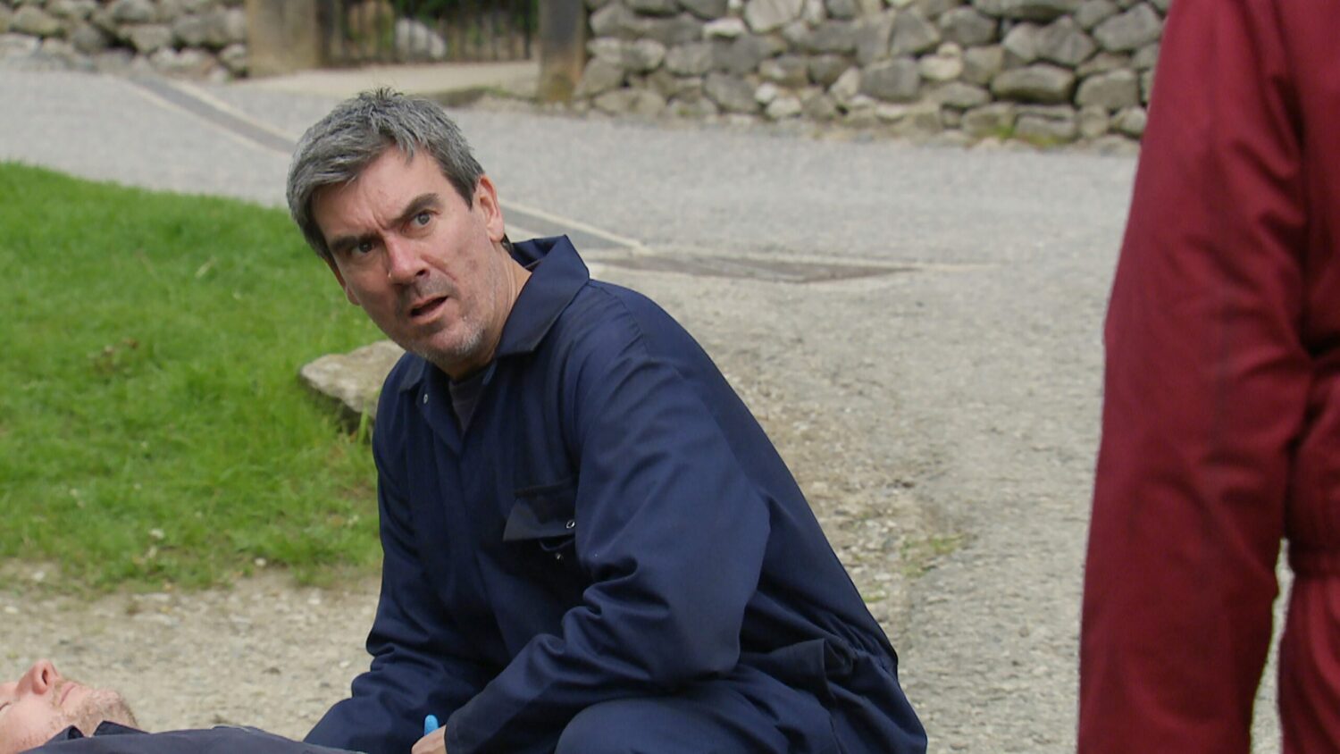 Emmerdale's Cain is looking up at Dan with horror as he tends to Lloyd outside