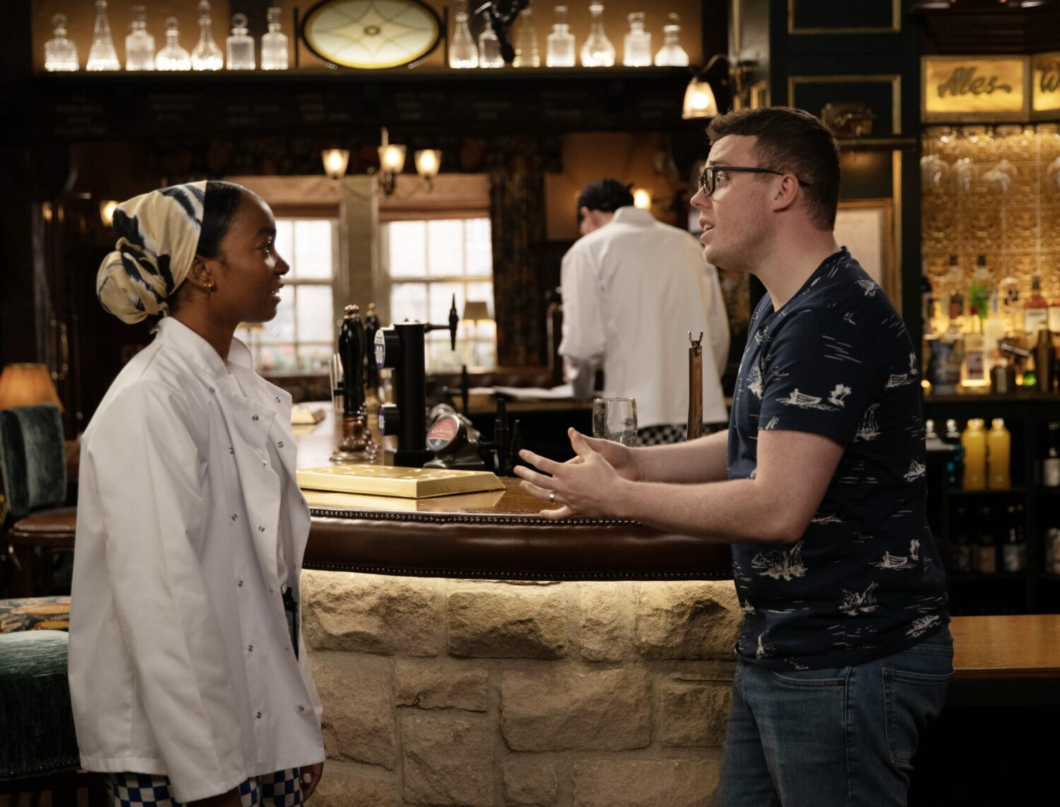 Naomi and Vinny are locked in stressed conversation in the Woolpack