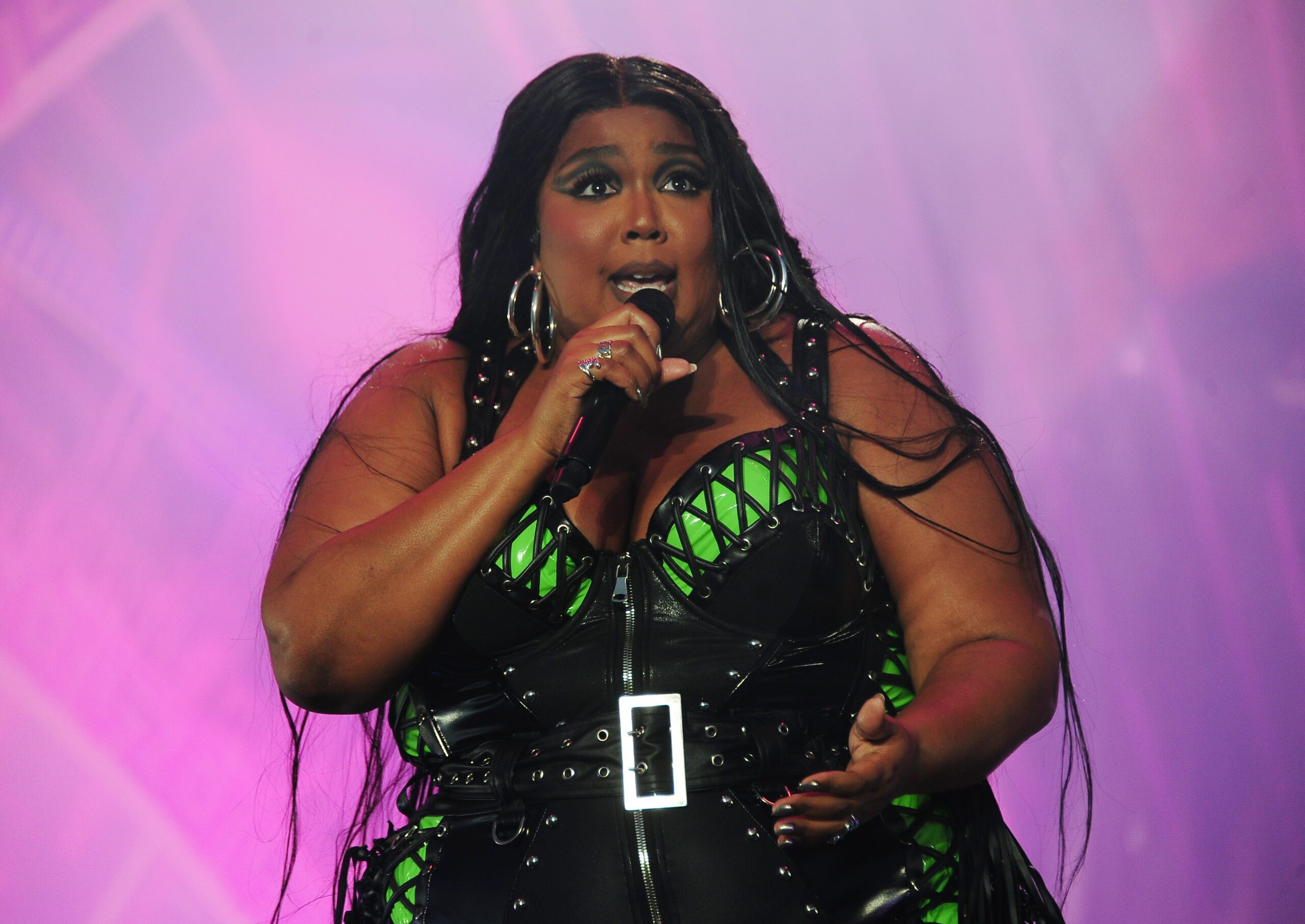Lizzo signs during performance