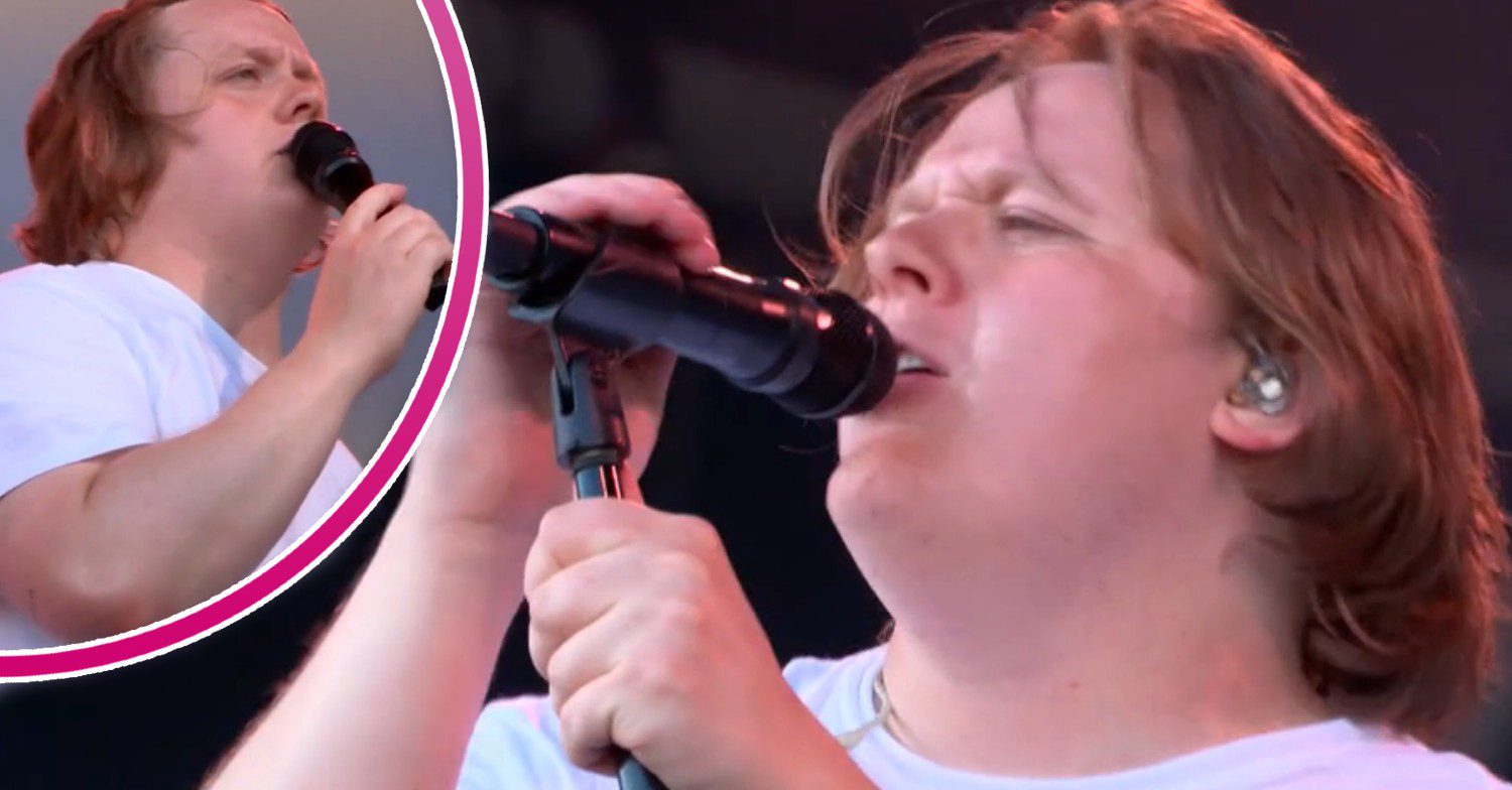 Lewis Capaldi singing at Glastonbury with a microphone in his hand