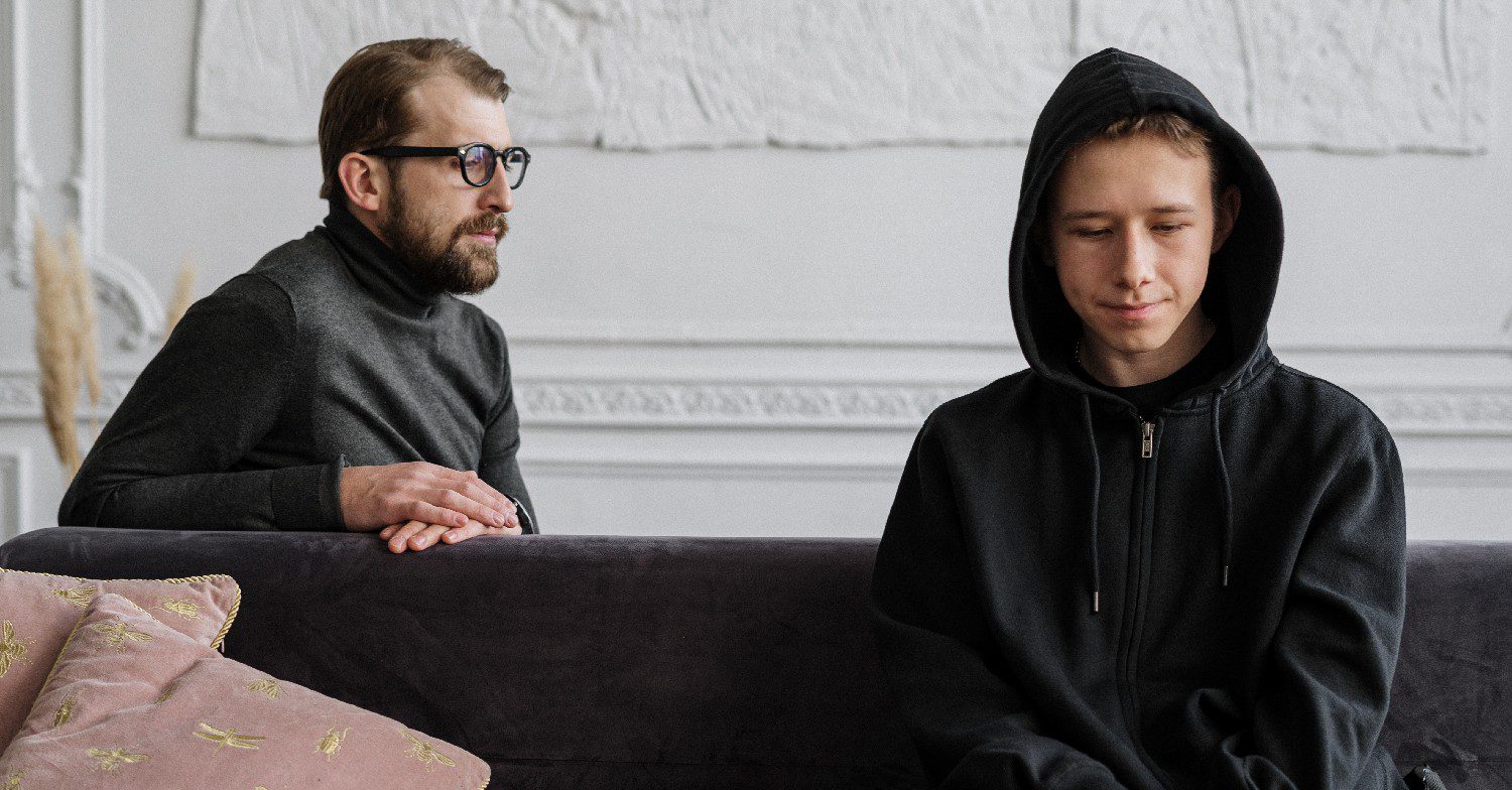 Father speaking to sad son