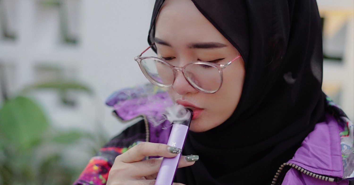 A girl vaping a pink vape