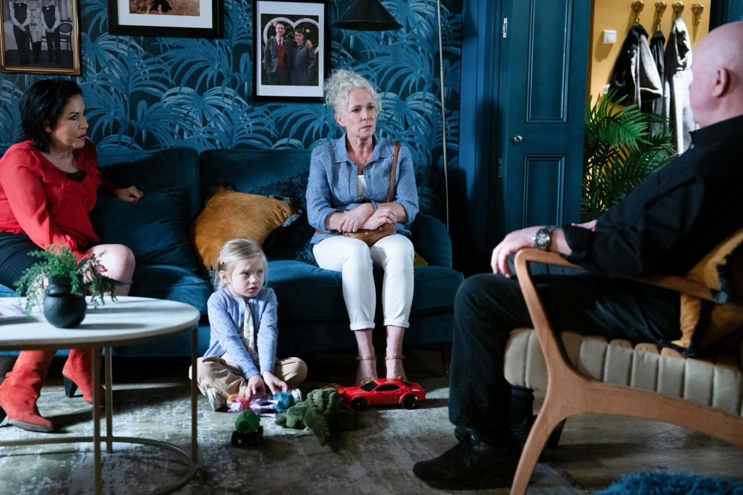 Kat looks suspicious and Lisa uncomfortable as she sits and talks to Phil in EastEnders