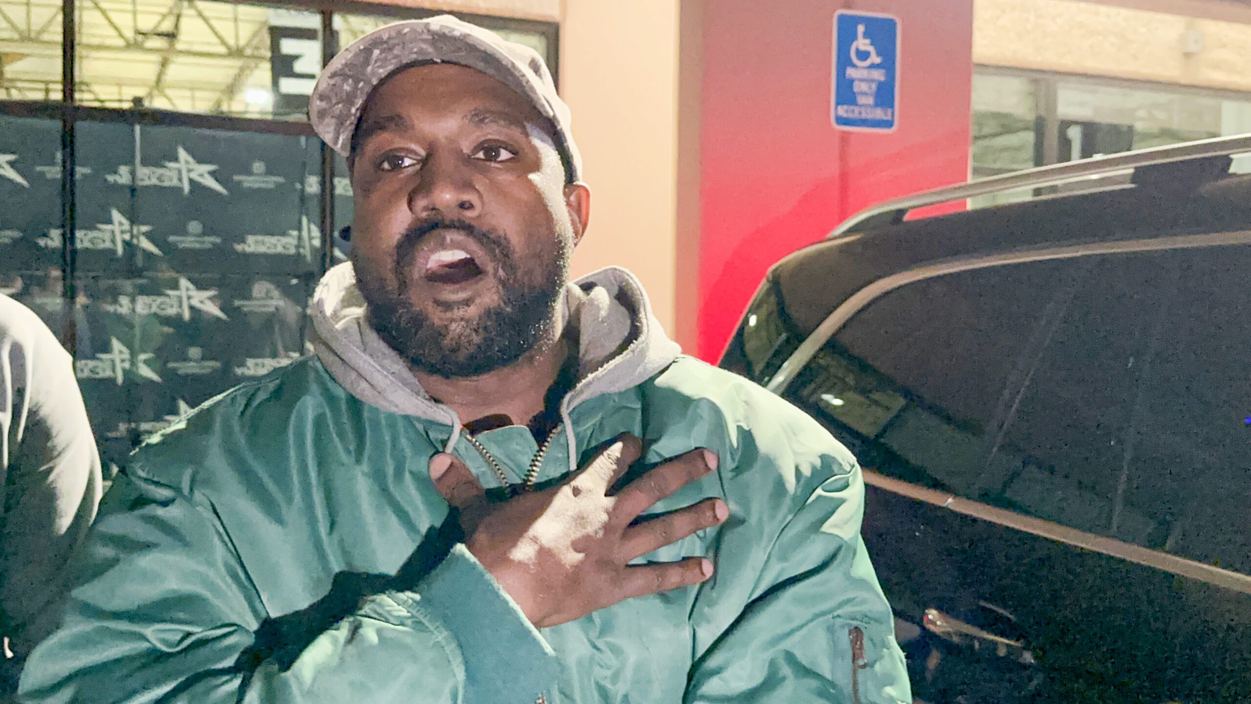 Kanye West wears cap as he shouts