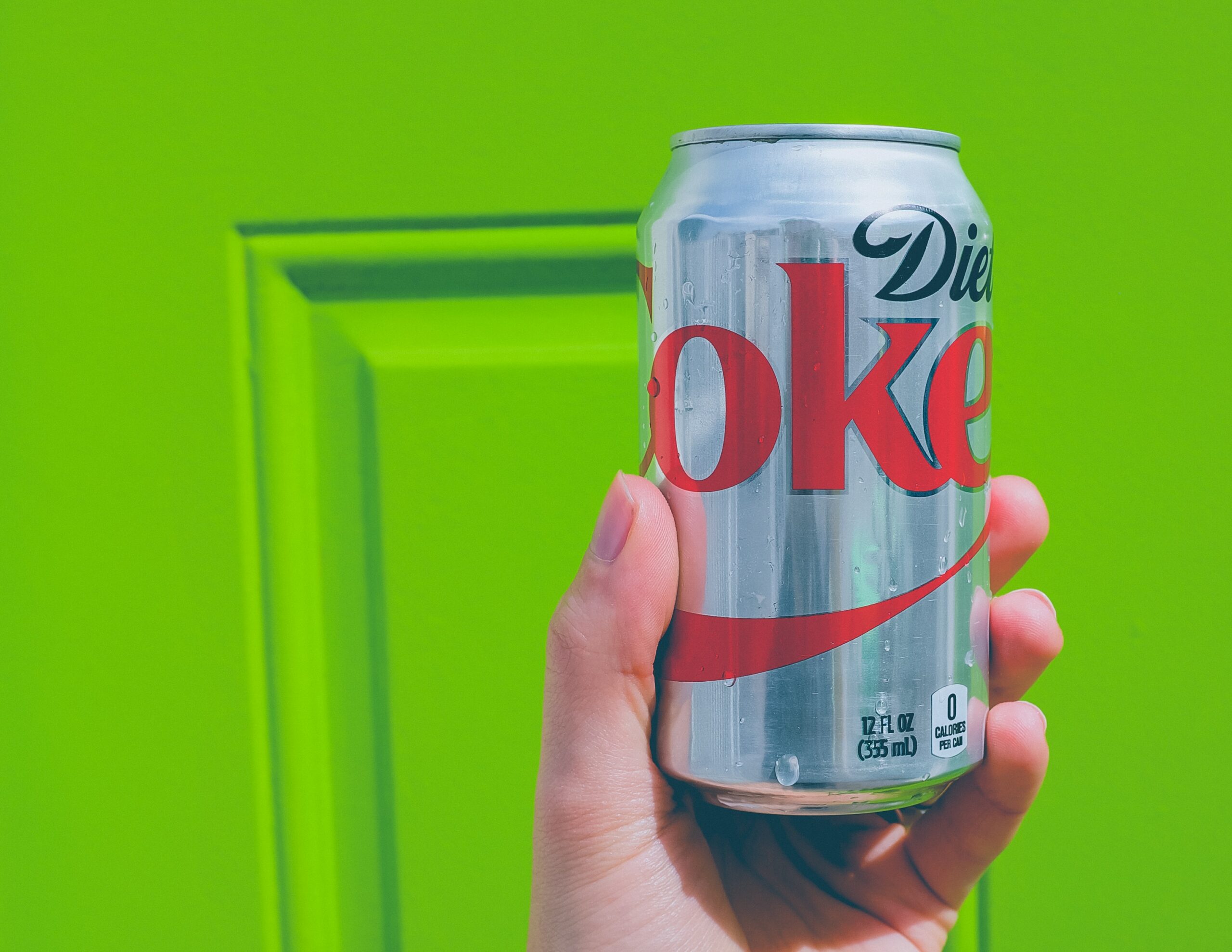 Diet Coke can in front of green door