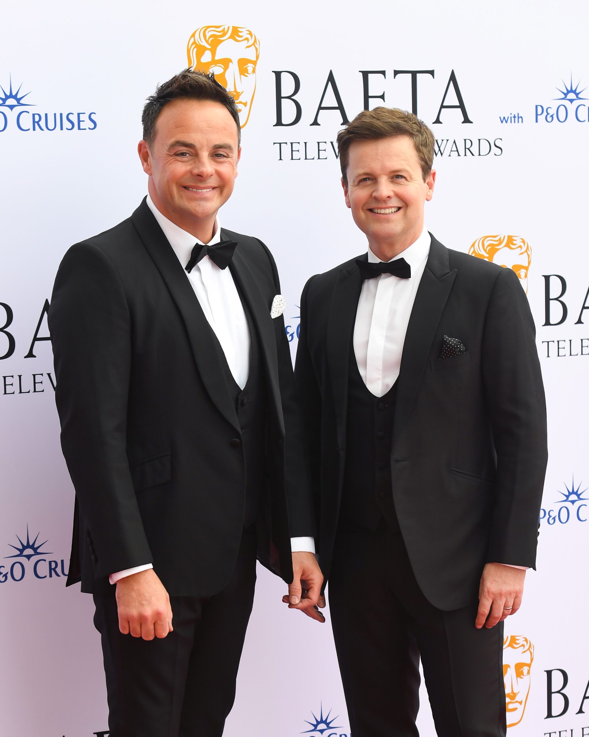 Ant and Dec smiling on the red carpet in tuxedos