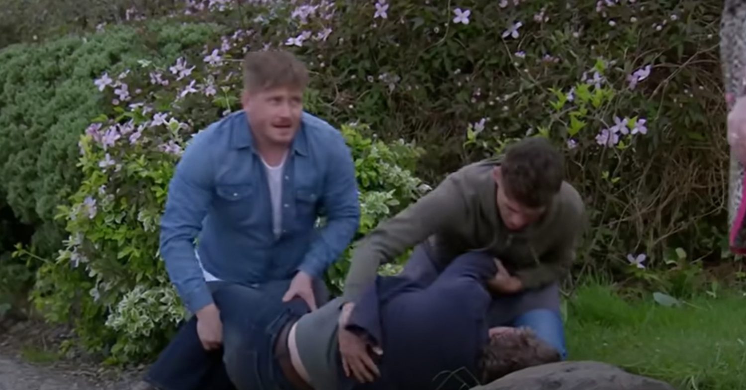 Emmerdale's David and Jacob are knelt down next to Lloyd outside