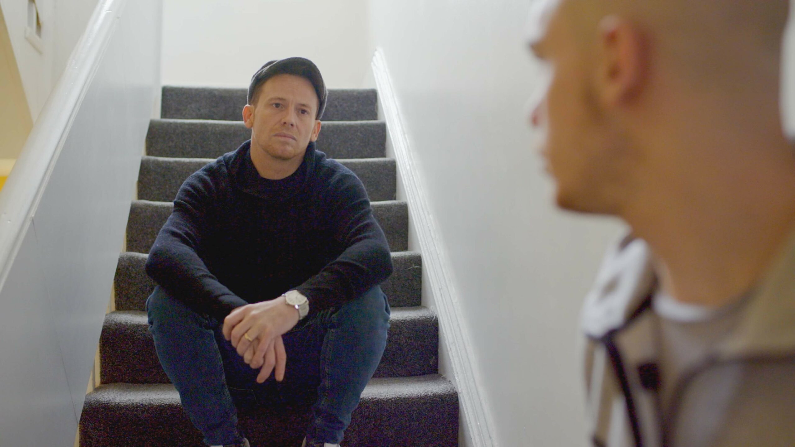 Joe Swash sitting on a stair during the making of Joe Swash: Teens in Care