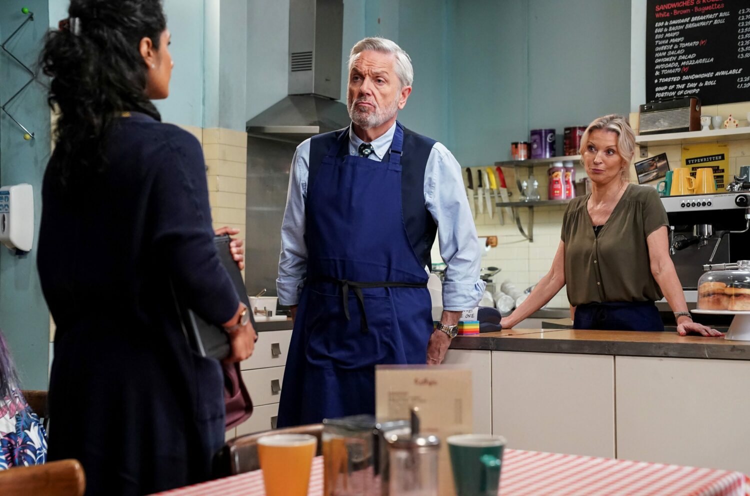 Kathy Beale looks unimpressed in the cafe with Rocky and Suki