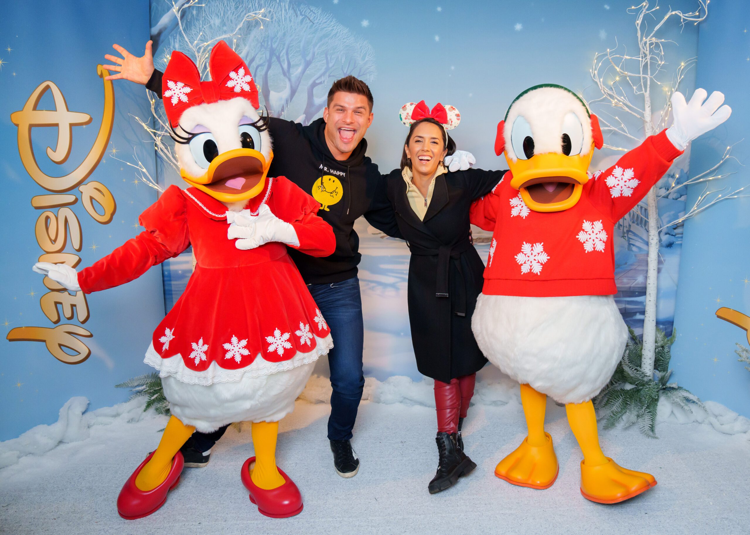 Janette Manrara and Aljaž Skorjanec smiling with Donald and Daisy Duck