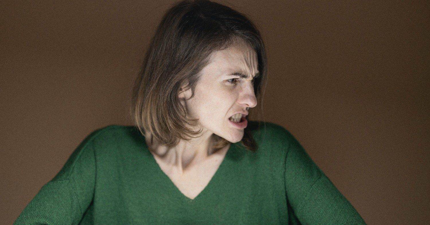 Woman in green snarling