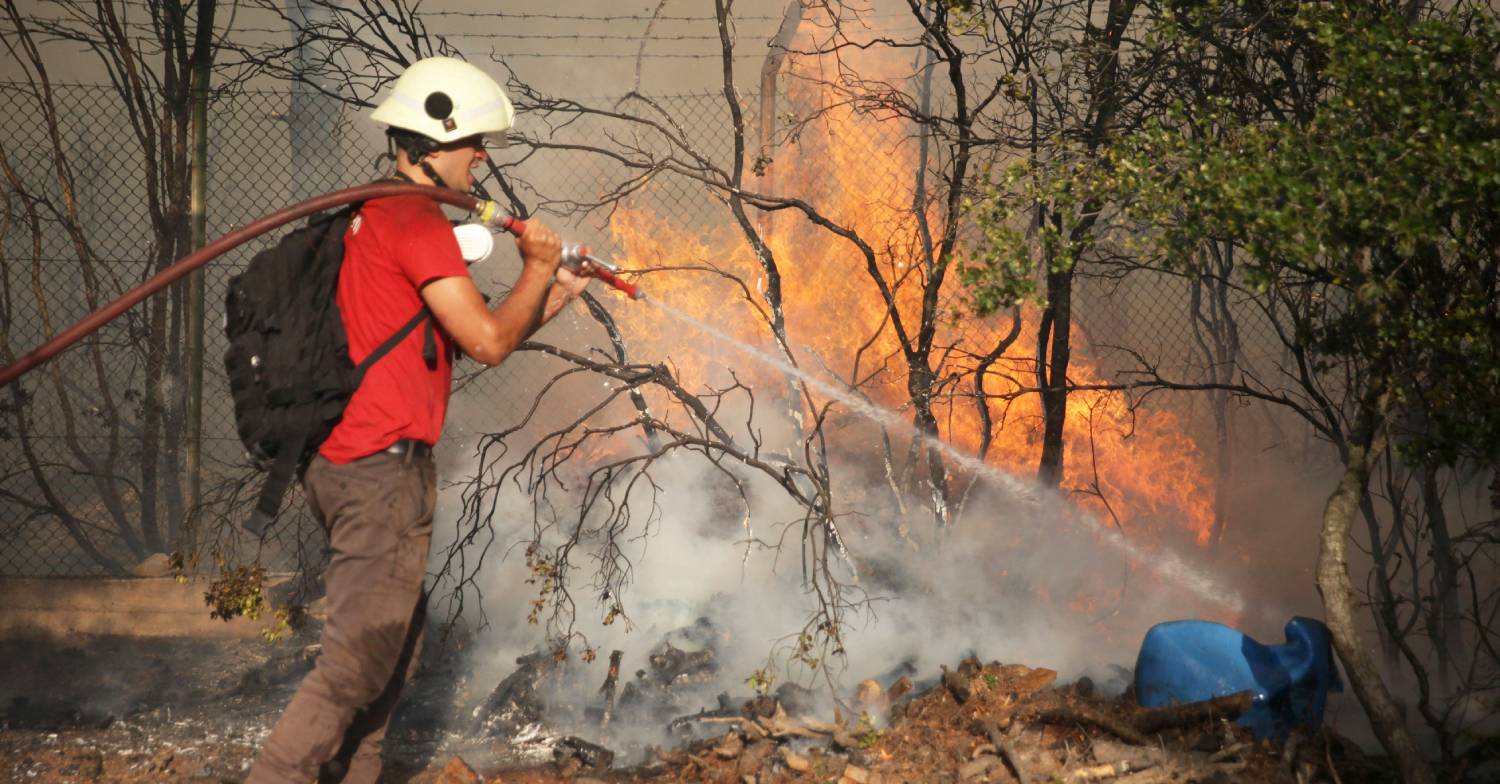 A firefighter tries to put out a wildfire in the area of Mandra, West Attica, in Greece
