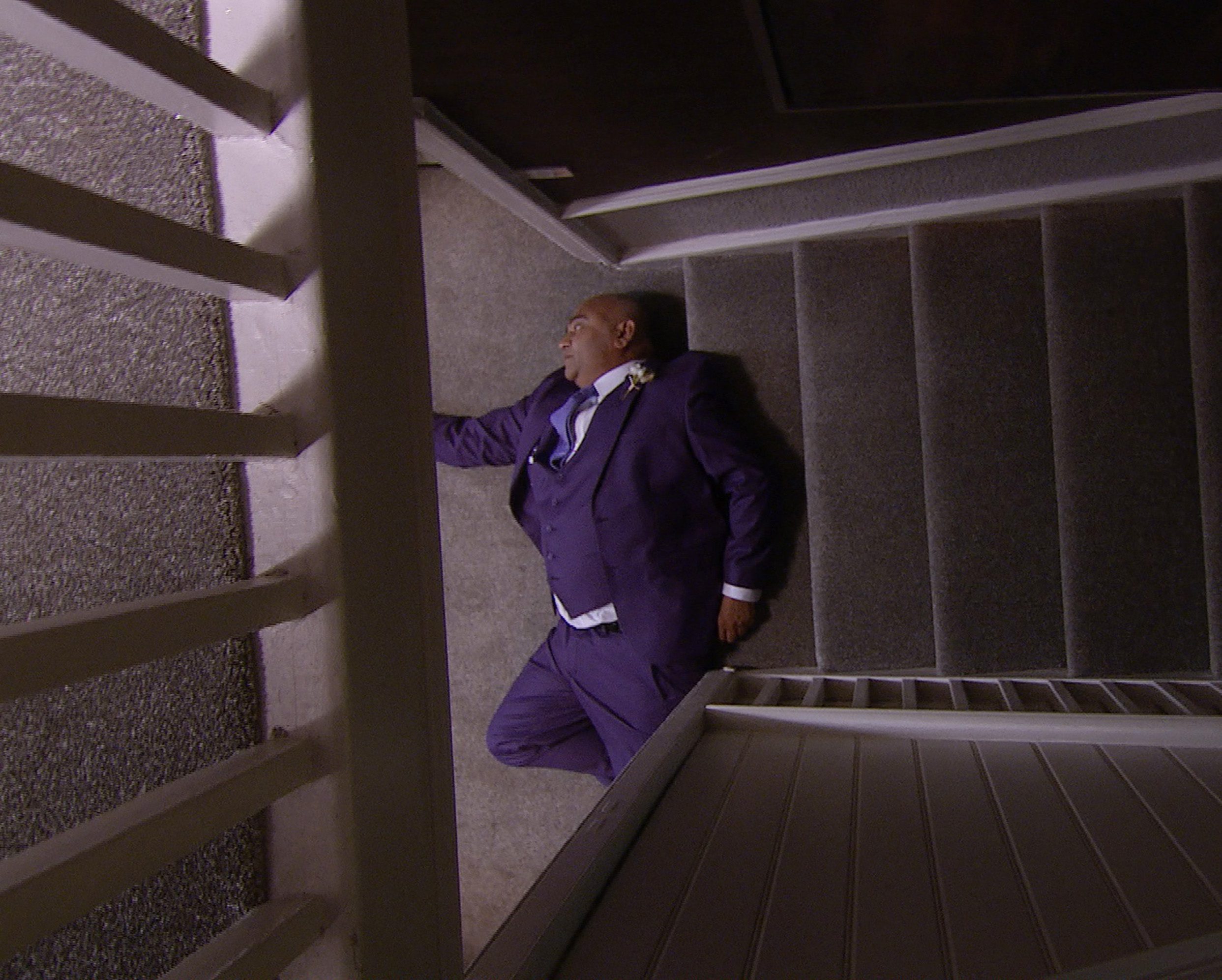 Rishi lying dead at the bottom of the stairs on Emmerdale