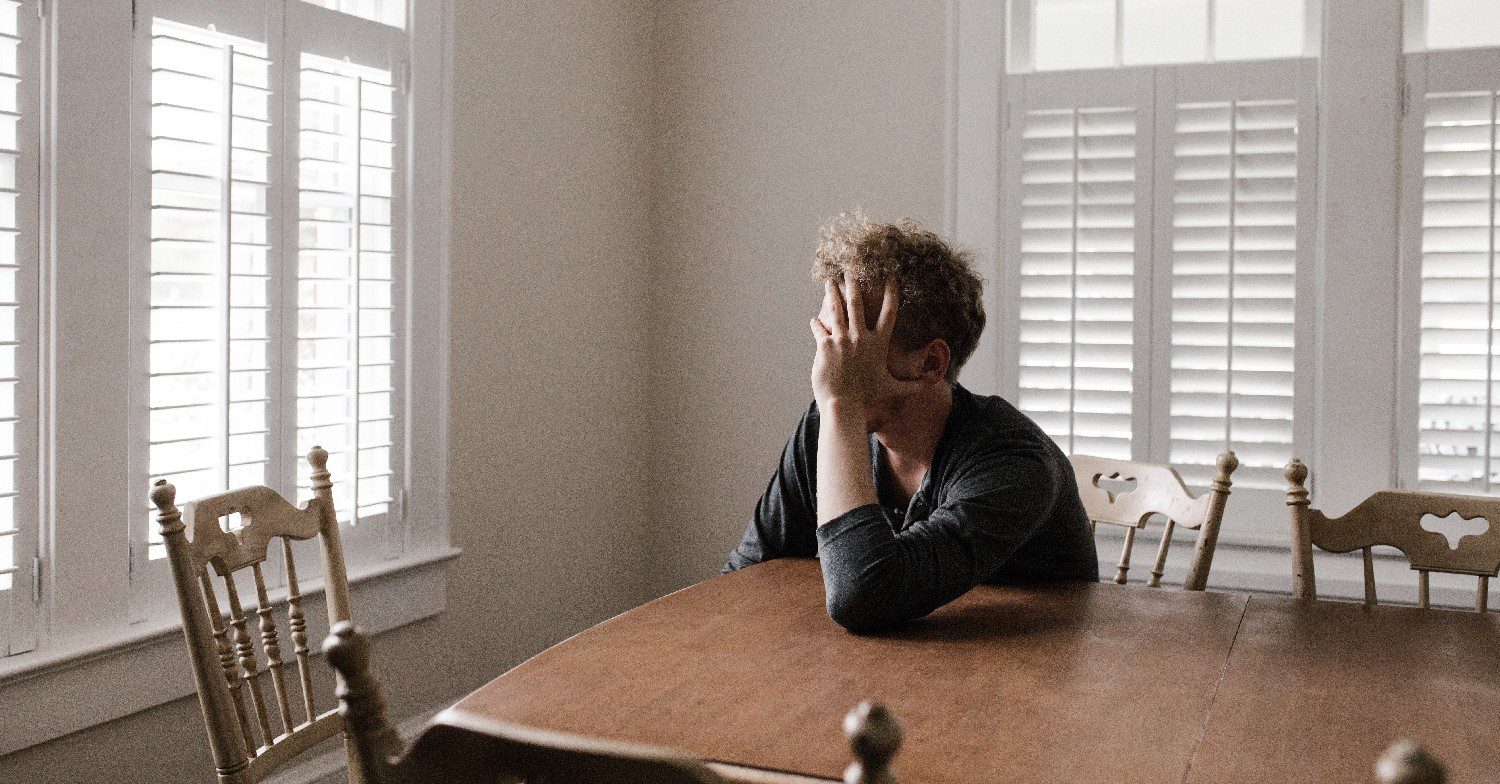 Man sad at the kitchen table 