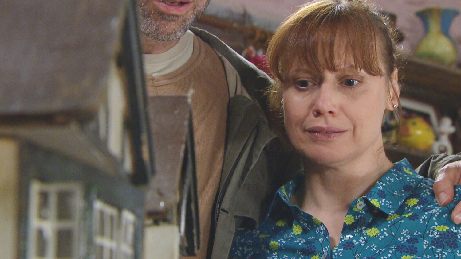 Lydia looks emotional as she looks at a dollhouse with Sam on Emmerdale