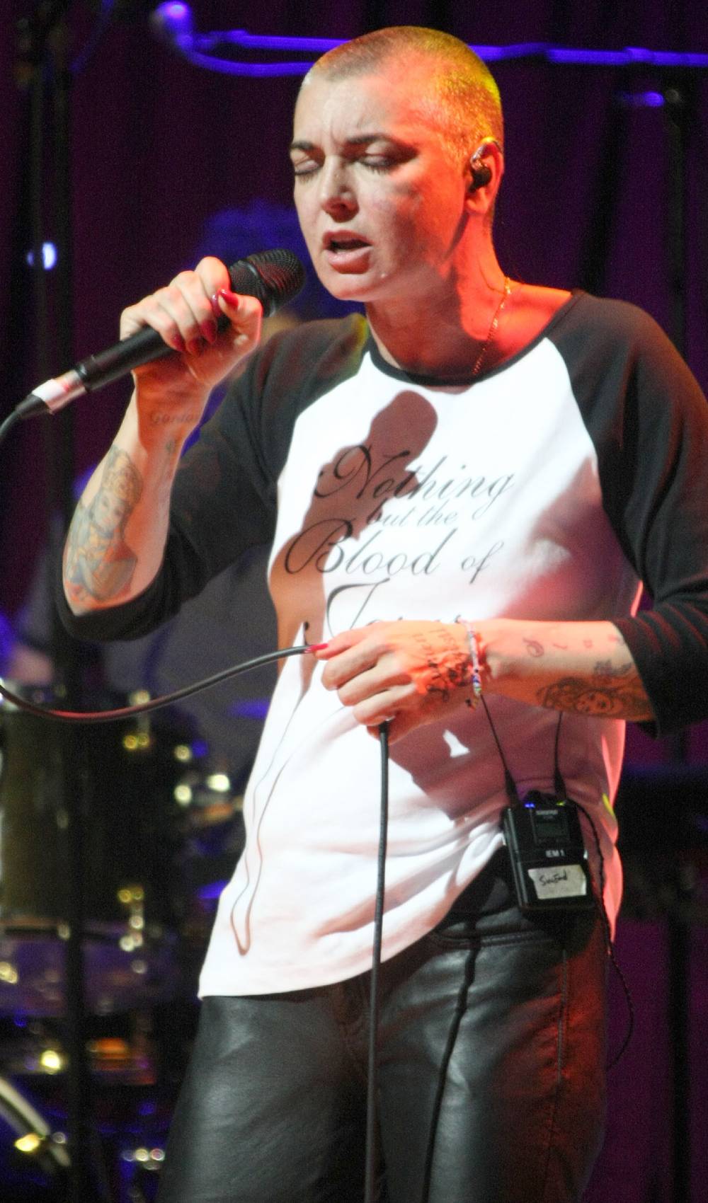 Sinead O'Connor sings into a microphone