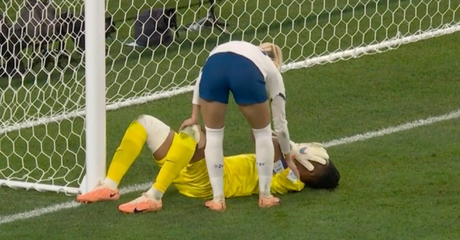 Chloe Kelly bends down to help player