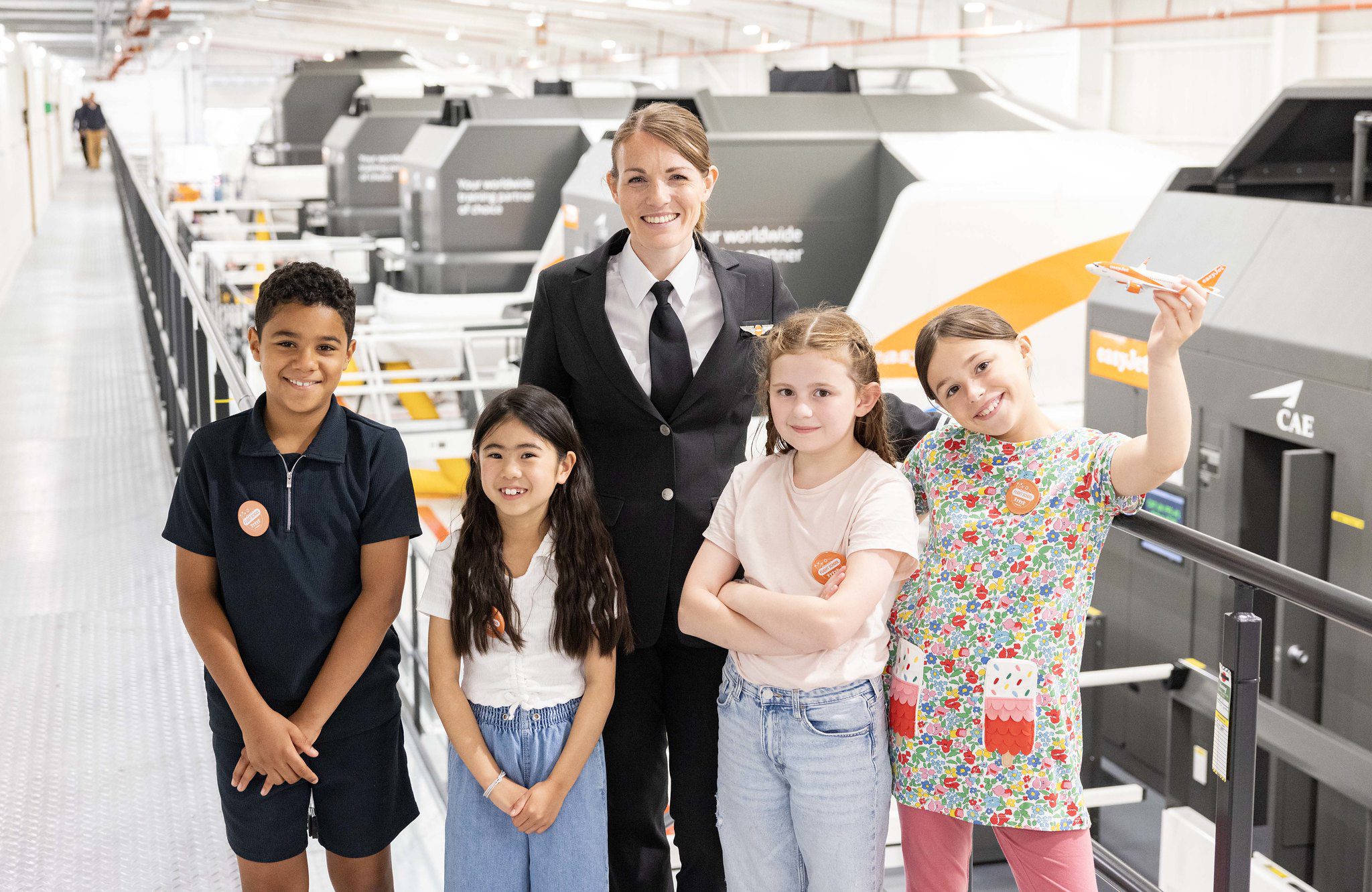 Children and a pilot standing outside a plane cockpit