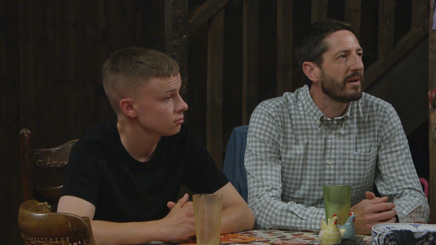 Samson and Craig sit at the Dingles' table looking confused