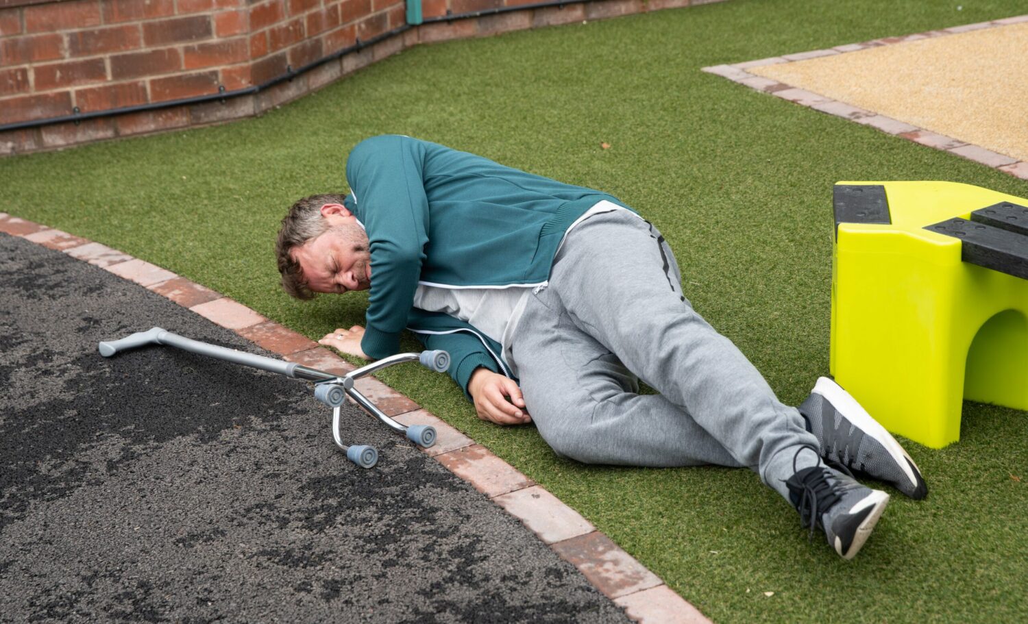Paul in Coronation Street lies on the ground in pain and frustration