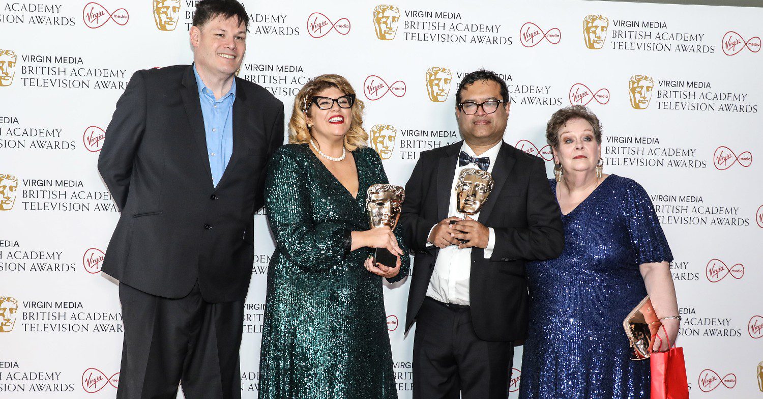 Paul Sinha and quizzers from The Chase smiling at the BAFTA TV Awards holding an award