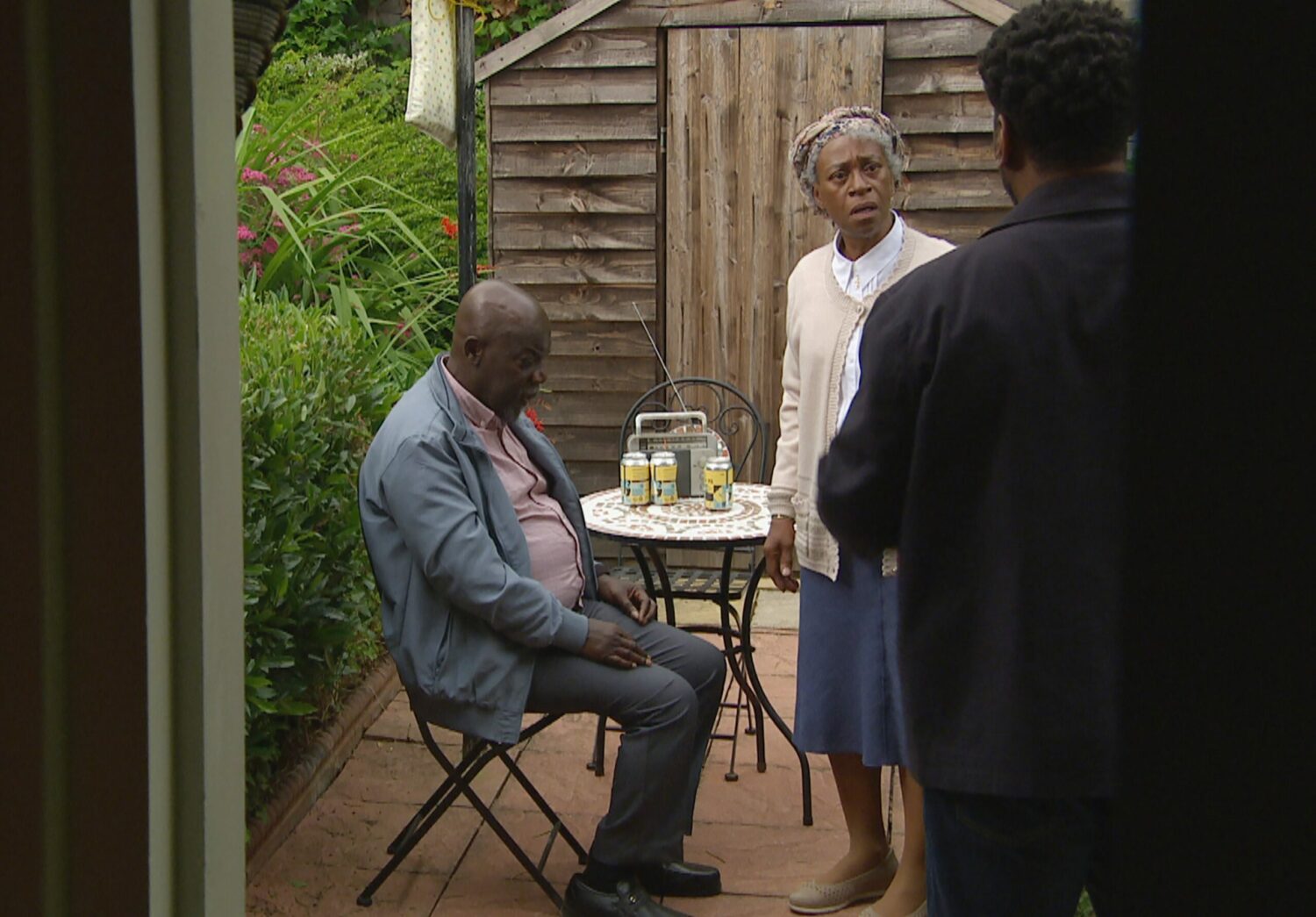 Charles looks on as Claudette and Victor sit in the garden