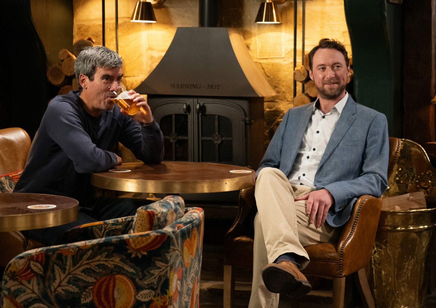 Liam smiles as he drinks with Cain on Emmerdale