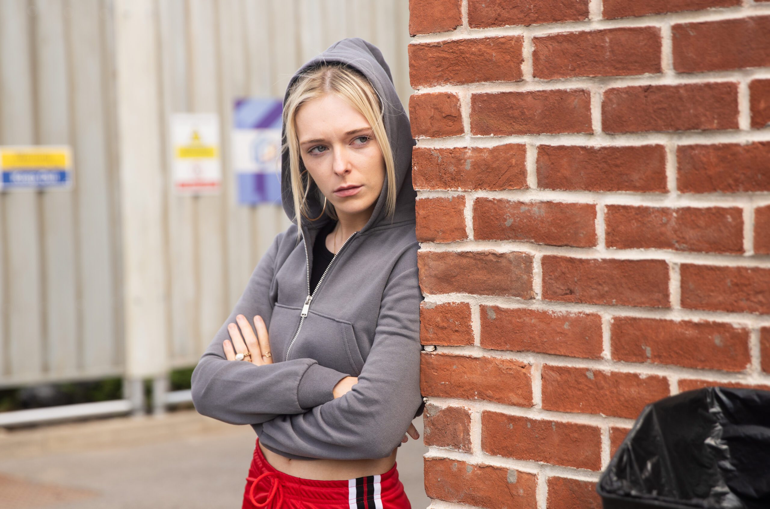 Coronation Street's Lauren has her hood up, hiding behind a wall