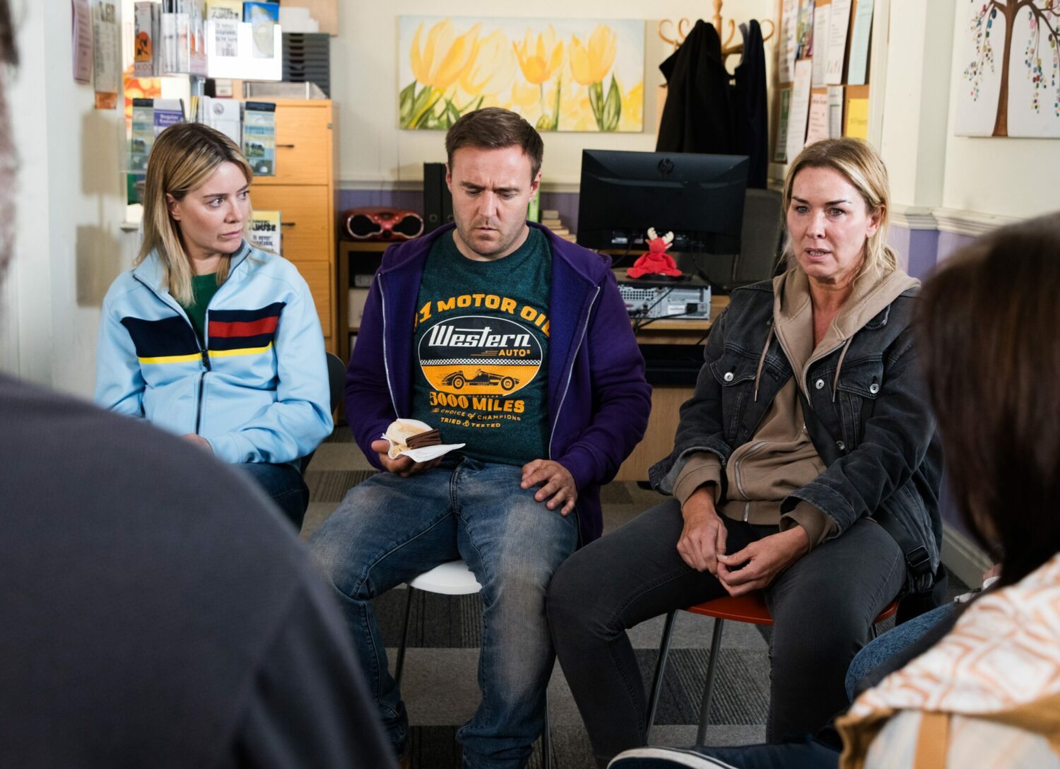 Abi, Tyrone and Cassie all look upset and stressed at a support group in Coronation Street