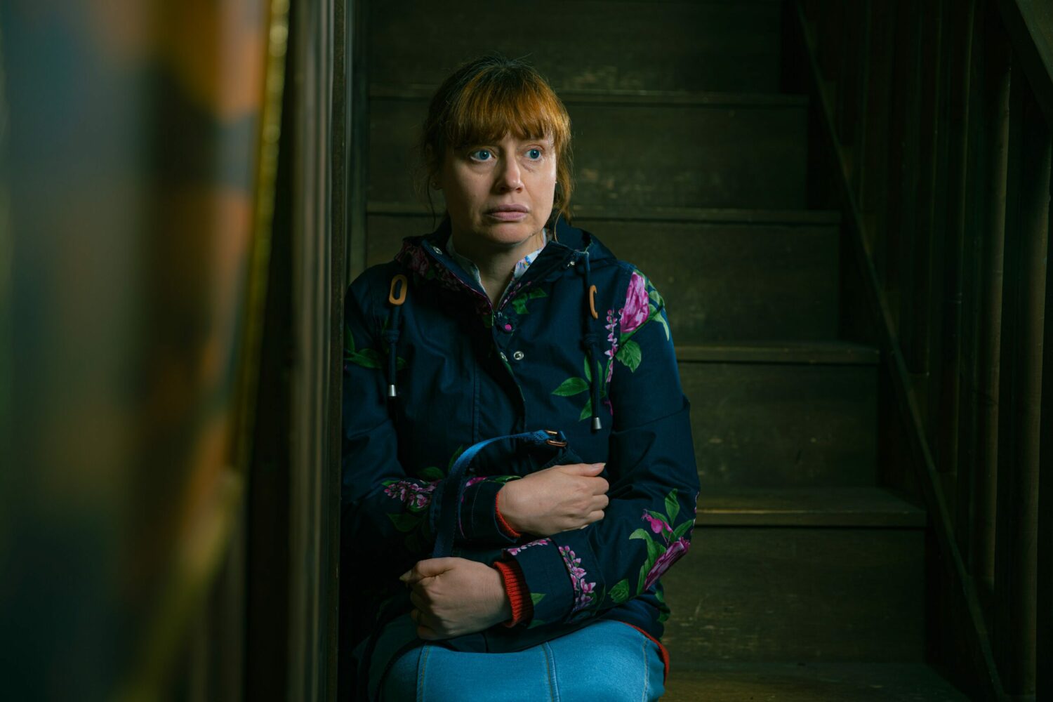 Lydia Dingle sits on the stairs clutching her handbag in a state of shock