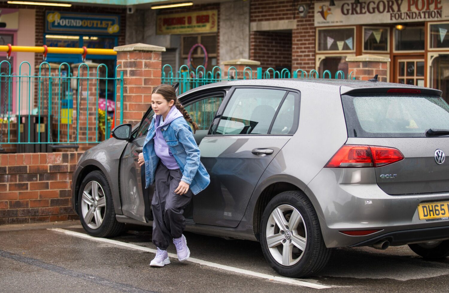 Coronation Street's Eliza is standing in front of a car at the Precinct